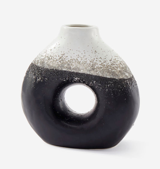 Cylindrical ceramic vase with black and white speckled design on a white background