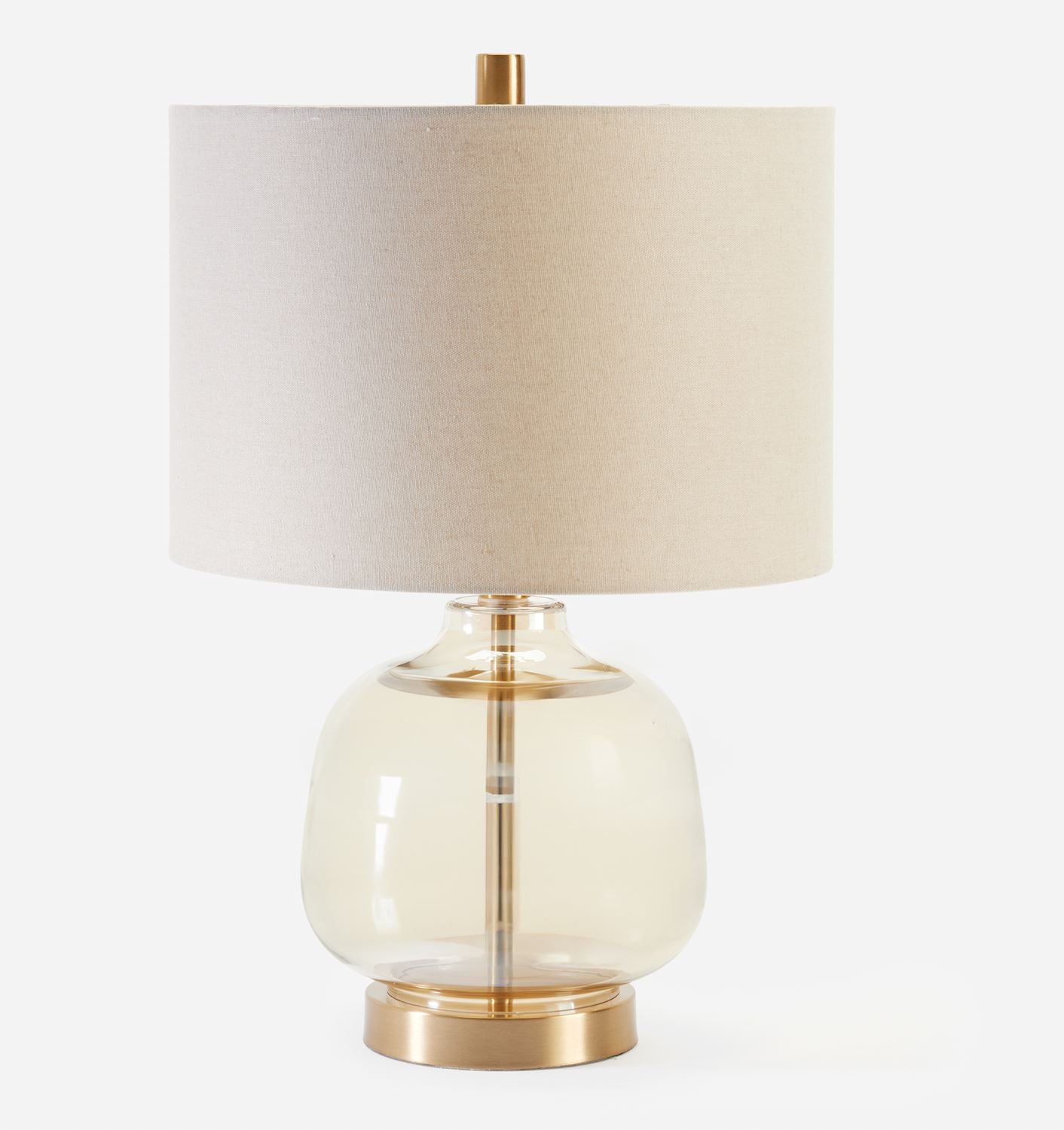 Table lamp with a beige shade and glass base on a white background