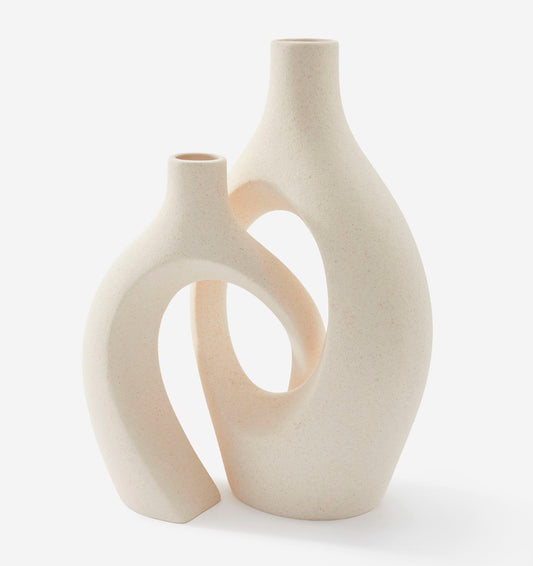 Two cream-colored ceramic vases with a modern design on a white background
